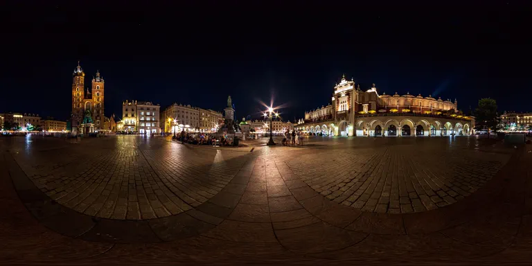 A night view of the Main Market Square in Kraków, with the Cloth Hall and St Mary's Basilica.