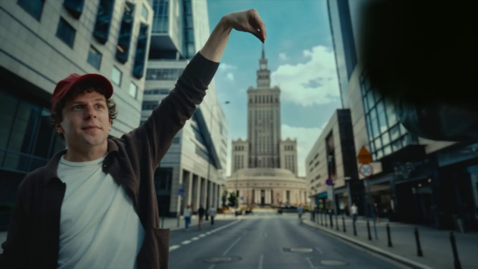 A man on the street in front of the Palace of Culture and Science in Warsaw.