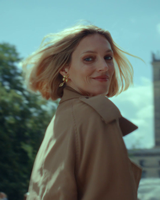 Anja Rubik spoglądająca przez ramię na tle Warszawy.