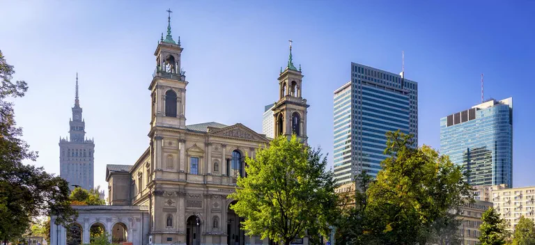 All Saints Church and skyscrapers by Grzybowski Square in Warsaw.